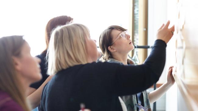 People co-working on a whiteboard