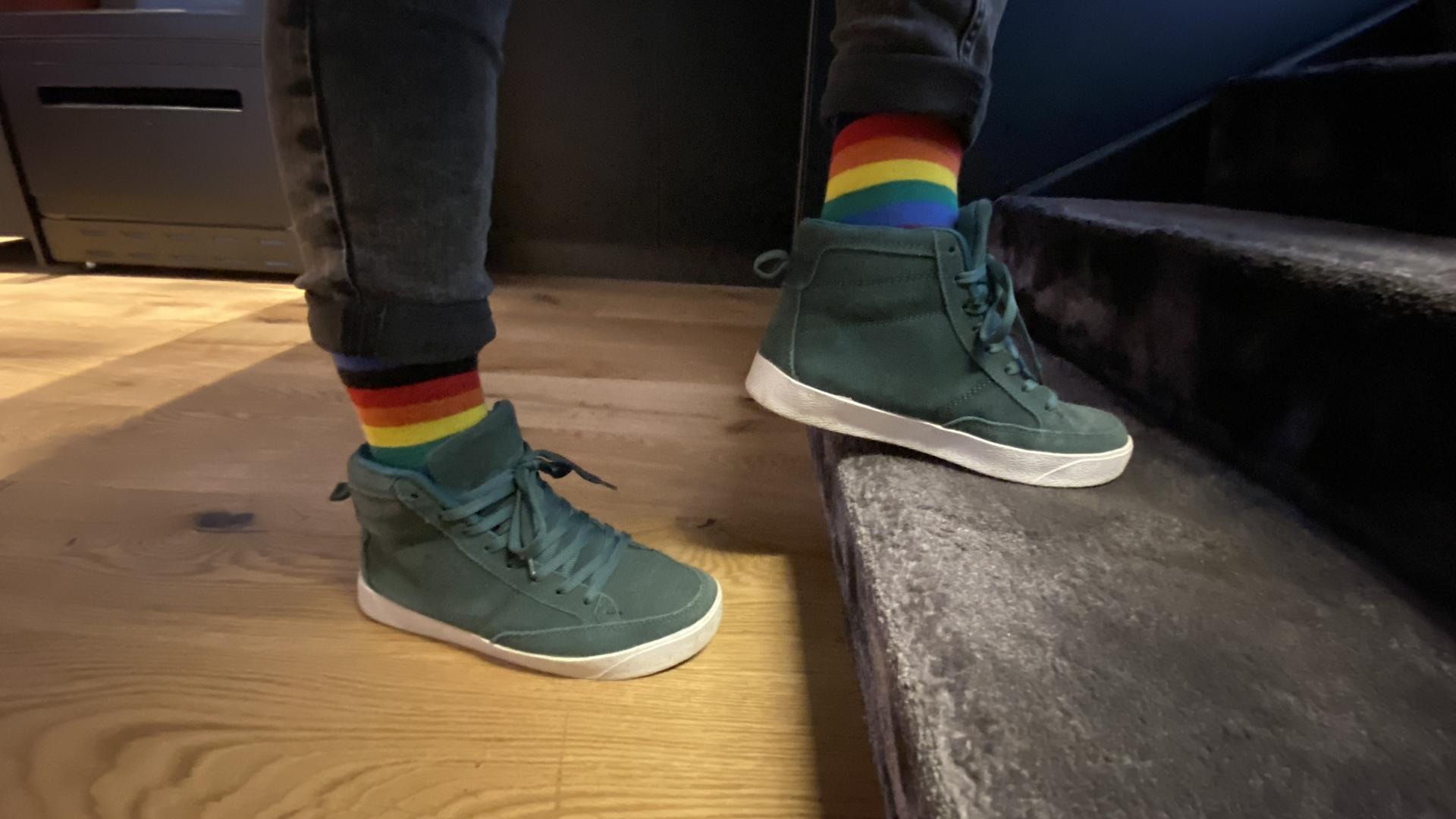 Closeup photo of persons feet in sneakers and colorful socks climbing stairs