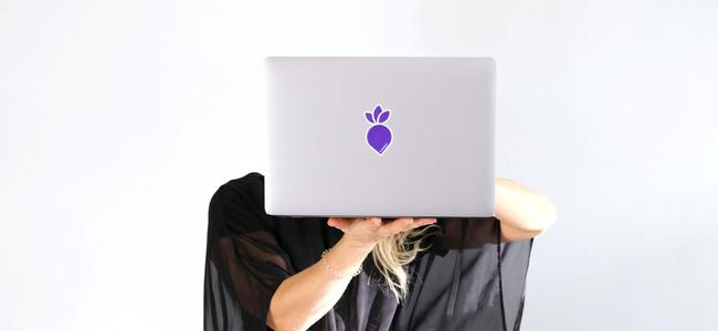 Nainen pitää kannettavaa tietokonetta kasvojensa edessä