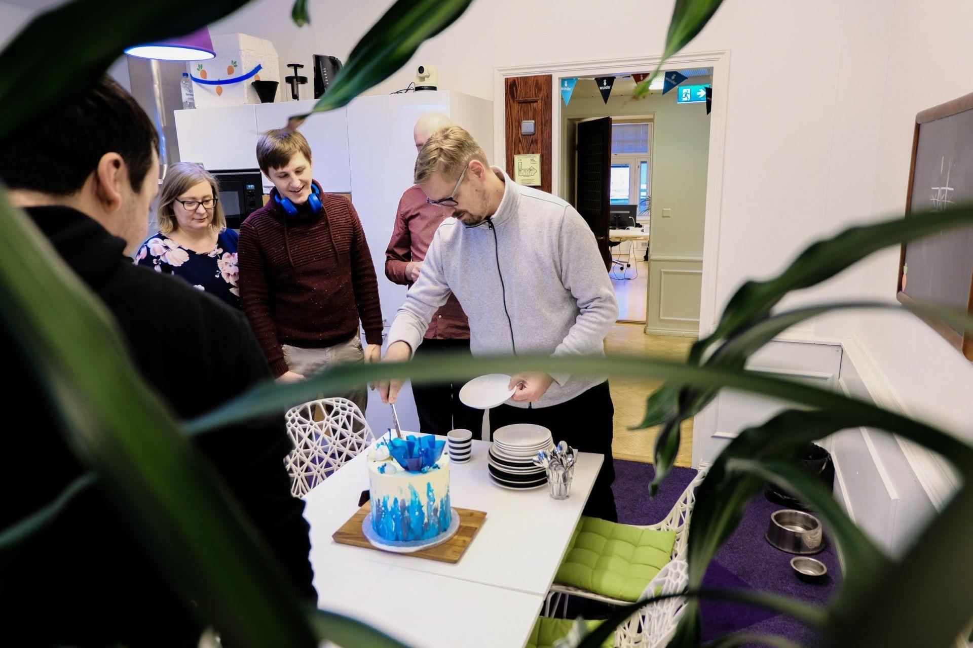 Wunderers around a Drupal-themed cake at Wunder Helsinki office's kitchen.
