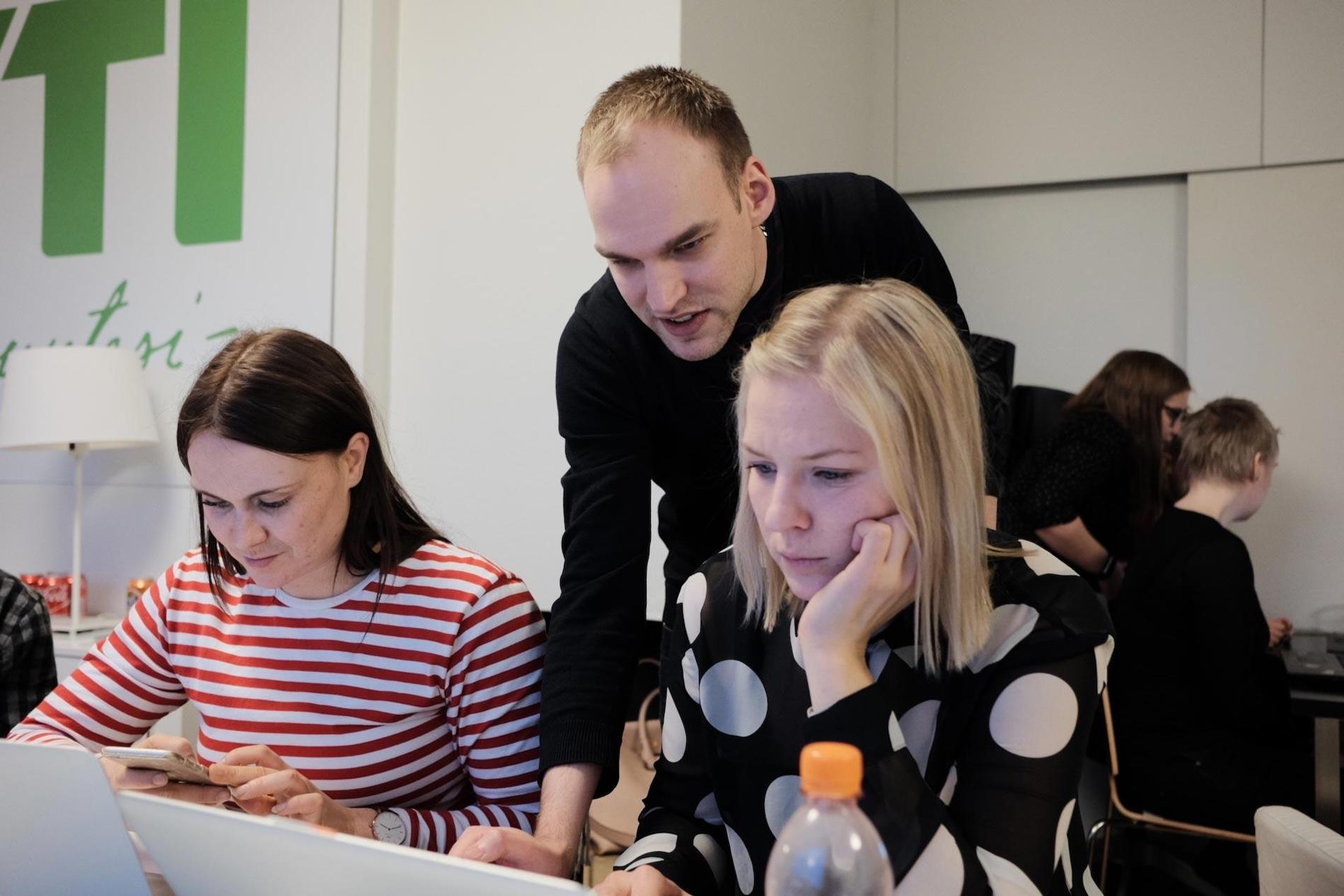 Jan Lindström helping two female coders